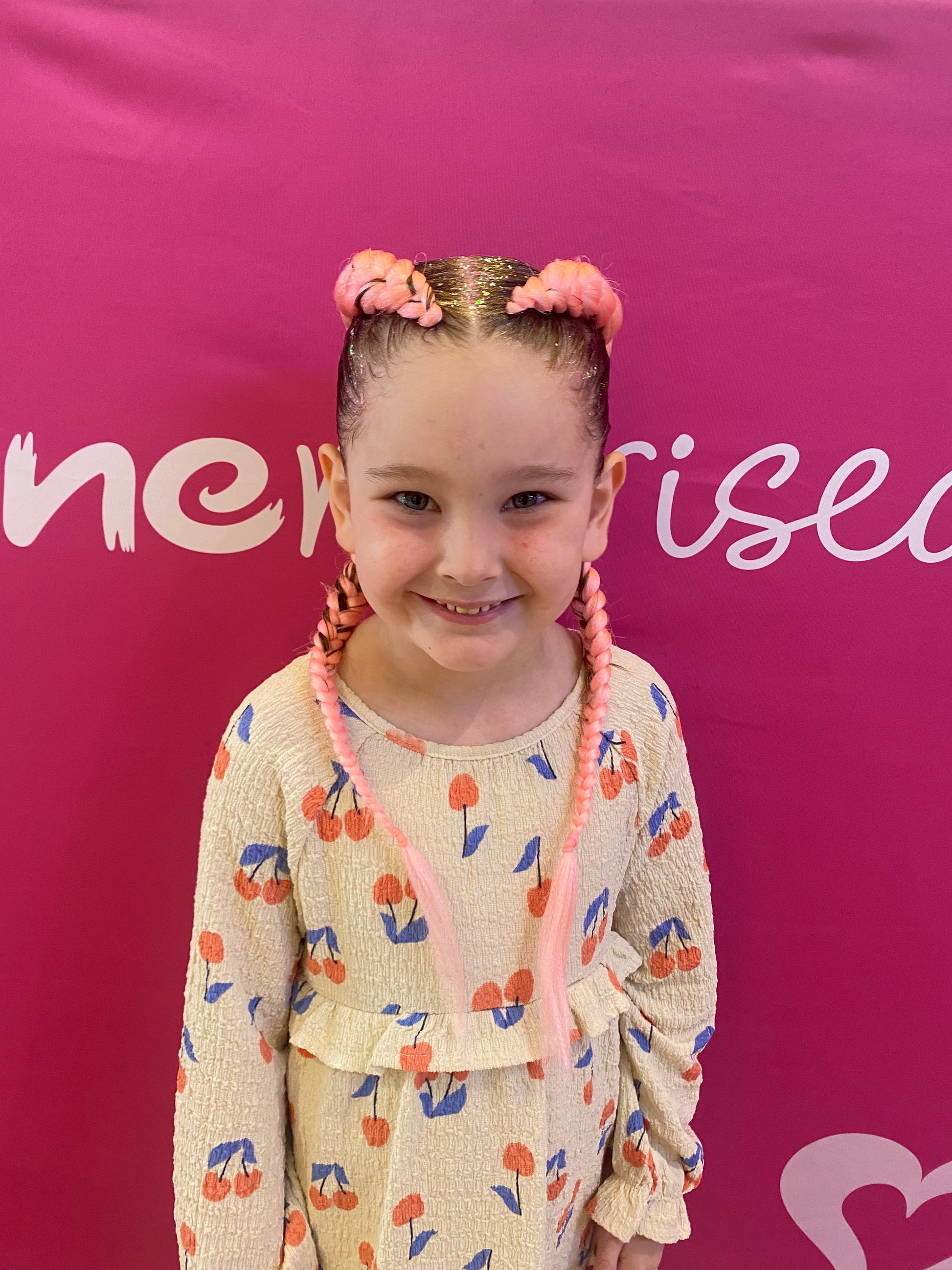 Front view of coral-pink braids showing the finished hairstyle.